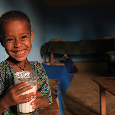 Girl drinking milk produced by the family cow (ILRI / Apollo Habtamu).