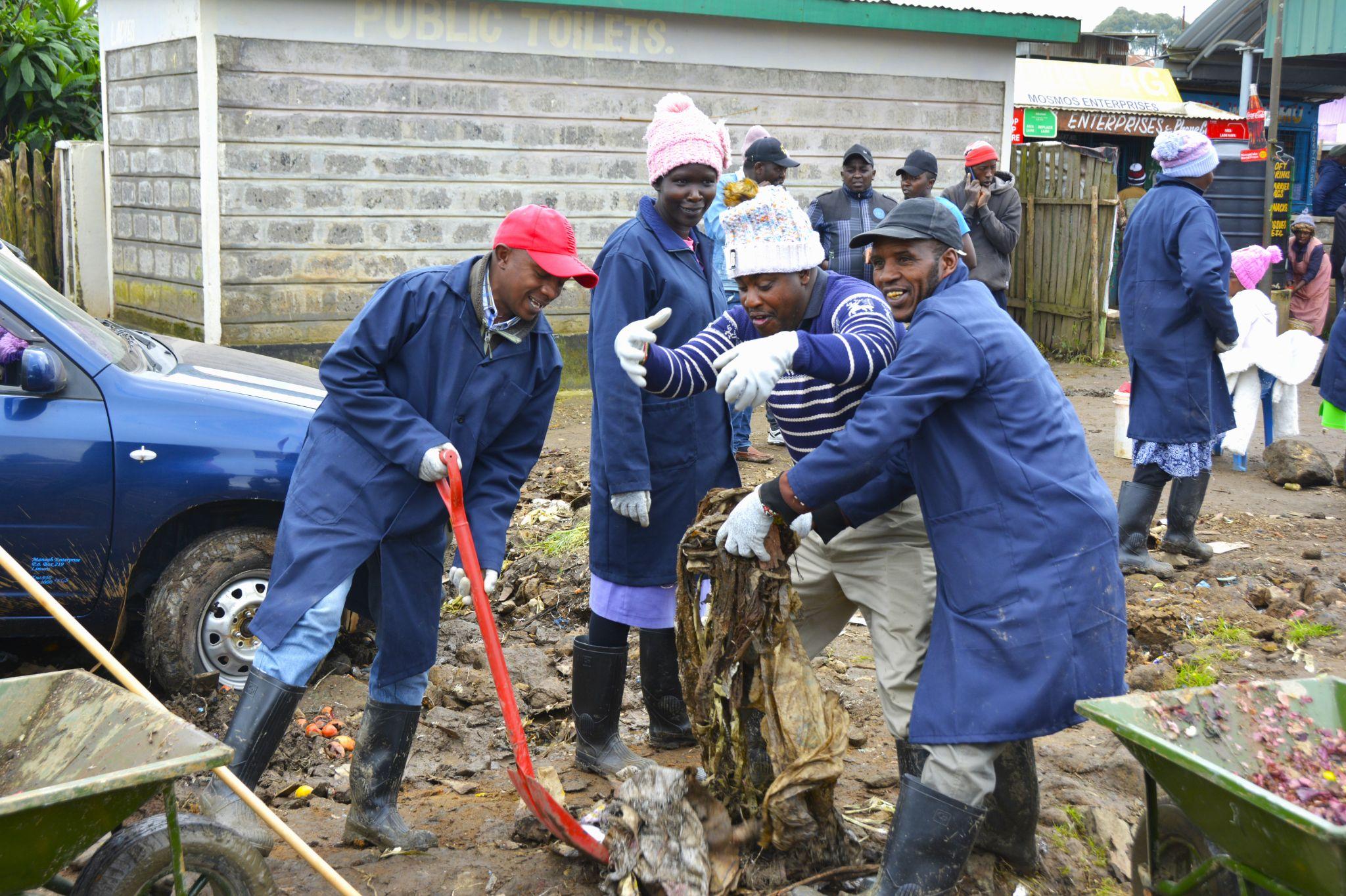 Cleaning up trash from the ground and placing it in wheelbarrows. Photo: Fenja Tramsen/ ILRI.