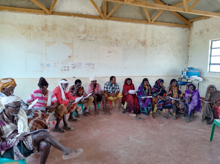 A group of people sitting in a circle</p>
<p>Description automatically generated