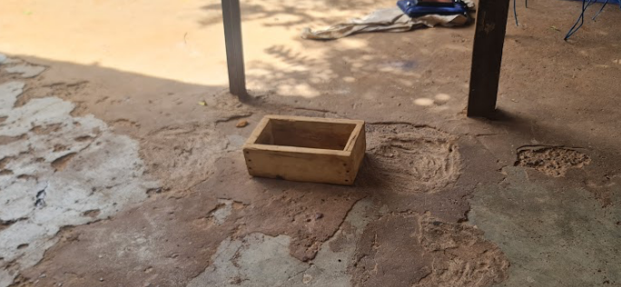 A wooden box on the ground</p>
<p>Description automatically generated