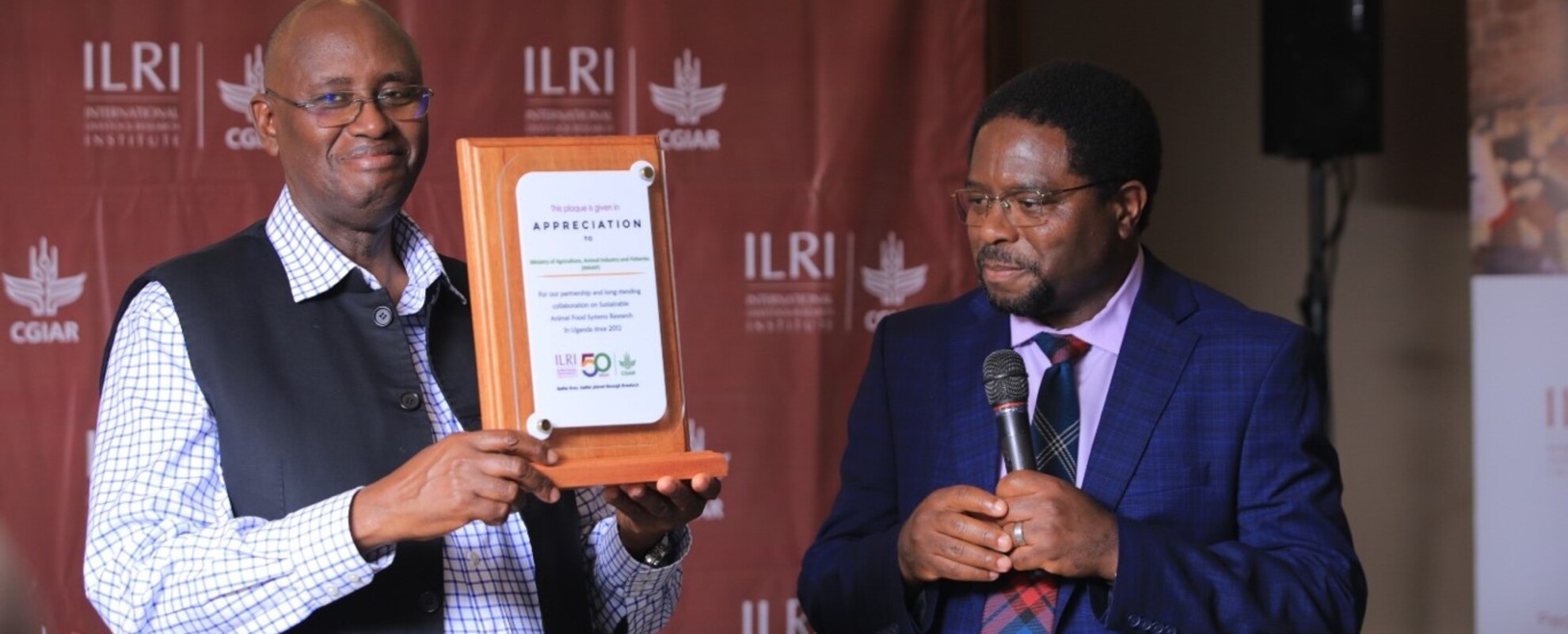 International Livestock Research Institute (ILRI) director general, Apollinaire Djikeng (right), presented a plaque to the Minister of State for Animal Industry, Hon. Bright Rwamirama, in appreciation of the support accorded to the ILRI by the ministry over the past 12 years (photo credit ILRI/Go Promotions).